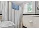 Compact bathroom with a modern sink, classic white subway tile, and striped shower curtain at 1314 Glendale Ave, Durham, NC 27701
