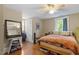Cozy bedroom features hardwood floors, a ceiling fan, and a large window for natural light at 1314 Glendale Ave, Durham, NC 27701
