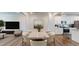 Sunlit dining room with modern table set next to kitchen with white cabinets at 1314 Rosepine Dr, Cary, NC 27519