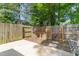 Features backyard with privacy fence, mature trees, concrete patio, and stainless steel grill at 1316 Garden Crest Cir, Raleigh, NC 27609