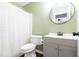 Bathroom features modern vanity, round mirror, toilet and shower with patterned curtain at 1316 Garden Crest Cir, Raleigh, NC 27609