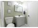 Bathroom with a gray vanity, toilet, and a modern mirror with soft green walls at 1316 Garden Crest Cir, Raleigh, NC 27609