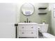 Updated bathroom with stylish vanity, round mirror, floating shelves, and neutral décor at 1316 Garden Crest Cir, Raleigh, NC 27609