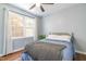 Well-lit bedroom with wood floors, large window with white curtains and blue bedding at 1316 Garden Crest Cir, Raleigh, NC 27609