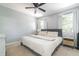 Bright bedroom featuring a comfortable bed, ceiling fan, and windows with sheer curtains at 1316 Garden Crest Cir, Raleigh, NC 27609