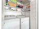 Convenient laundry area features a white washer and dryer, with storage shelves above at 1316 Garden Crest Cir, Raleigh, NC 27609