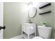 Half bathroom features a marble vanity, toilet, and a modern round mirror at 1316 Garden Crest Cir, Raleigh, NC 27609