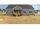 Gray two story home with a wooden porch, windows, and a spacious yard at 134 Royal Ave, Selma, NC 27576