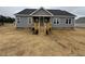 Traditional home featuring a covered porch, gray siding, a dark roof and white trim at 134 Royal Ave, Selma, NC 27576