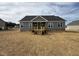 New home showcasing its back exterior with a wooden porch, gray siding, and a neatly installed roof at 134 Royal Ave, Selma, NC 27576