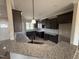 Modern kitchen with granite countertops, dark cabinetry, stainless steel appliances, and a breakfast bar at 134 Royal Ave, Selma, NC 27576