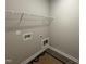Functional laundry room including connections for a washer and dryer and a built-in storage rack at 134 Royal Ave, Selma, NC 27576