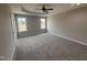 Serene main bedroom with neutral tones, plush carpeting, large windows, and a ceiling fan at 134 Royal Ave, Selma, NC 27576