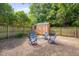 Backyard with a shed and a blue chair seating area, surrounded by mature trees at 1429 Hudson Ave, Durham, NC 27705