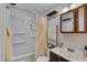 Bathroom featuring a shower/tub combo, dark vanity, and decorative shelving at 1429 Hudson Ave, Durham, NC 27705