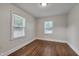 Bright bedroom with hardwood floors and natural light from the two large windows at 1429 Hudson Ave, Durham, NC 27705