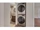 Modern stacked washer and dryer unit with a view into the full bathroom at 1429 Hudson Ave, Durham, NC 27705