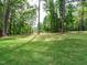 Lush backyard with mature trees, privacy fence, and a well-maintained lawn at 1481 Carolina Dr, Sanford, NC 27332