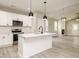 Open-concept kitchen provides a center island, stainless appliances, and opens to the living room with fireplace at 1481 Carolina Dr, Sanford, NC 27332