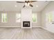 Inviting living room featuring a cozy fireplace, lots of natural light, and modern ceiling fan at 1481 Carolina Dr, Sanford, NC 27332