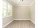 Light-filled room with a large window, neutral walls, and light wood-look flooring at 1481 Carolina Dr, Sanford, NC 27332