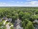 Expansive aerial view showing beautiful homes nestled amongst lush green trees and blue skies at 156 Yorkchester Way, Raleigh, NC 27615