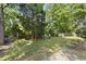 Lush backyard with mature trees, offering a serene and private outdoor space at 156 Yorkchester Way, Raleigh, NC 27615