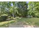Lush backyard with mature trees, offering a serene and private outdoor space at 156 Yorkchester Way, Raleigh, NC 27615
