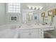 Bright bathroom with dual vanities, a large mirror, and a soaking tub, combining comfort and functionality at 156 Yorkchester Way, Raleigh, NC 27615