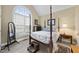 Spacious bedroom features a four-poster bed, large window with natural light, and neutral decor at 156 Yorkchester Way, Raleigh, NC 27615