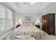 Bright, airy bedroom with a vaulted ceiling, floral bedspread, and natural light from large windows at 156 Yorkchester Way, Raleigh, NC 27615