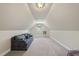 Versatile bonus room featuring sloped ceilings, a cozy sofa, and natural light from the window at 156 Yorkchester Way, Raleigh, NC 27615