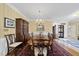 Traditional dining room with wooden table, chairs, chandelier, and ornate cabinet, perfect for formal gatherings at 156 Yorkchester Way, Raleigh, NC 27615
