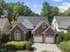 Beautiful brick home with a dark roof and manicured green bushes in a suburban neighborhood at 156 Yorkchester Way, Raleigh, NC 27615