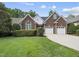 Attractive brick home with a two-car garage, complemented by lush green lawn and mature trees at 156 Yorkchester Way, Raleigh, NC 27615