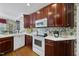 Functional kitchen featuring wood cabinets, white appliances, and charming wallpaper for a unique touch at 156 Yorkchester Way, Raleigh, NC 27615
