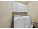 Well-equipped laundry room with a washer, dryer, and upper cabinets for storage at 156 Yorkchester Way, Raleigh, NC 27615