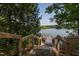 Backyard wooden steps leading down to private dock on a tranquil lake surrounded by nature at 1641 Silo Ridge Dr, Wake Forest, NC 27587