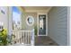 Inviting front porch with a round window, blue door, and wooden railing, creating a welcoming entrance at 1641 Silo Ridge Dr, Wake Forest, NC 27587
