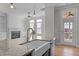 Kitchen island and farmhouse sink with hardwood floors open to living room with fireplace at 1641 Silo Ridge Dr, Wake Forest, NC 27587