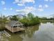 Charming lake house with a private dock, surrounded by lush greenery and serene water views at 1641 Silo Ridge Dr, Wake Forest, NC 27587
