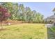 Spacious backyard features a well-maintained lawn, a patio area, and a fenced perimeter with trees at 1808 Capstone Dr, Durham, NC 27713