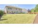 Expansive backyard featuring a well-maintained lawn, privacy fence, mature trees, and a cozy patio for outdoor enjoyment at 1808 Capstone Dr, Durham, NC 27713