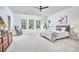 Spacious bedroom with plush carpet, ceiling fan, large windows, and modern decor at 1808 Capstone Dr, Durham, NC 27713