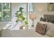 Comfortable bedroom setting with plush bedding, natural light and a stylish houseplant at 1808 Capstone Dr, Durham, NC 27713