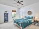 Cozy bedroom with a ceiling fan, window, comfortable-looking bed with teal bedding, and stylish furnishings at 1808 Capstone Dr, Durham, NC 27713