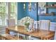 Dining room with wood table, white chairs, a bench, and an accent wall with windows at 1808 Capstone Dr, Durham, NC 27713