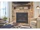 Close up of the stone fireplace with wooden mantle and decorative accent chair at 1808 Capstone Dr, Durham, NC 27713