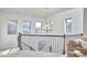 Hallway with an iron railing, chandelier, and multiple windows providing natural light at 1808 Capstone Dr, Durham, NC 27713