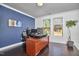 Home office featuring a large desk, hardwood floors, and natural light from two windows at 1808 Capstone Dr, Durham, NC 27713